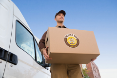 Delivery Man Carrying Cardboard Box By Truck Against Sky